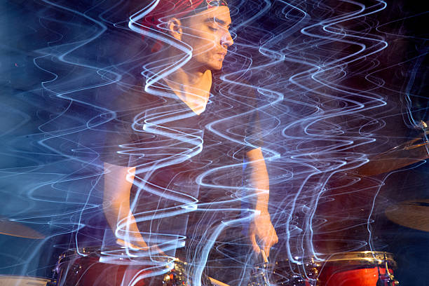 istock Young man drummer hitting drum kit in studio, long time of exposure, blurred motion 2220121073