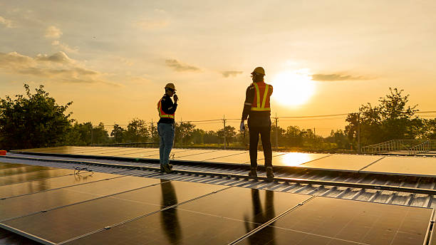 istock Silhouette of workers installing solar panels on a rooftop during sunset with a drone hovering nearby, highlighting renewable energy, innovation, and sustainable practices in solar technology. 2220121314