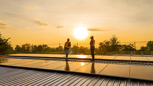 istock Silhouette of workers installing solar panels on a rooftop during sunset with a drone hovering nearby, highlighting renewable energy, innovation, and sustainable practices in solar technology. 2220121425
