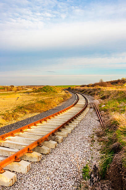 istock Empty railway tracks turning left, sunny vertical evening picture 2220122751