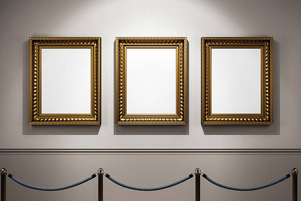 istock Three classic golden frames hanging on a clean gallery wall under spotlight in an empty exhibition hall with rope barrier in front view. 3D Rendering 2220122832