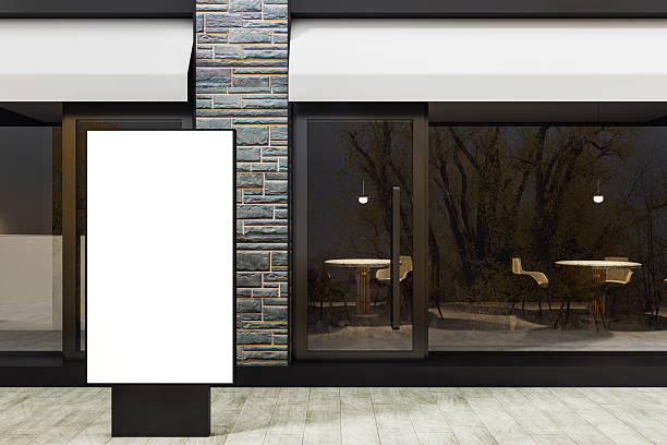 istock Modern storefront exterior with empty lightbox display stand for advertising mockup on tiled street background at night with glass entrance door. 3D Rendering 2220122872