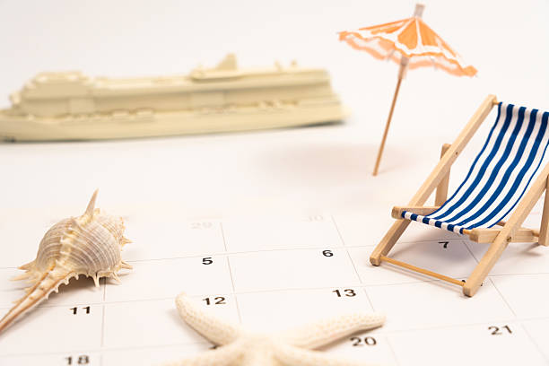 istock Cruise liner, seashells, deckchair, beach umbrella resting on calendar, representing summer vacation planning 2220122893