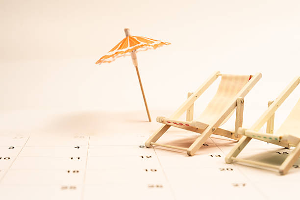 istock Summer vacation planning featuring miniature beach chairs, umbrella resting on calendar page, signaling relaxing travel anticipation 2220122987