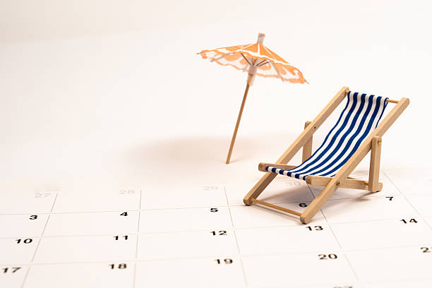 istock Vacation planning with miniature beach accessories, calendar marking sunny days, representing travel anticipation and summer leisure dream 2220123036