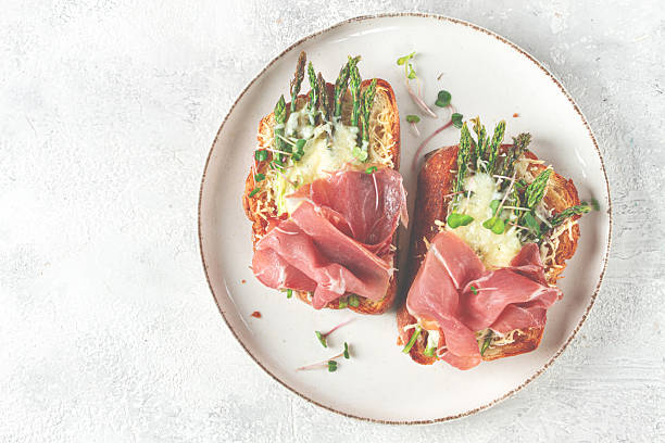 istock open sandwiches with asparagus and prosciutto, with cheese, breakfast, on a plate, 2220127210
