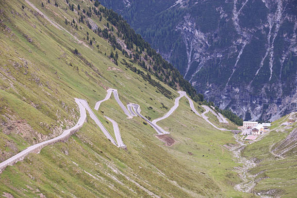 Porsche 911 GT3 (Generation 991) sports car driving on an alpine road along the Timmelsjoch pass. The Timmelsjoch Mountain Pass, also known as Passo del Rombo in Italian, is a high mountain pass that straddles the border between Austria and Italy. It connects the Ötztal valley in the Austrian state of Tyrol with the Passeier Valley in the Italian province of South Tyrol. The road across the Timmelsjoch Pass is a spectacular route renowned for its scenic beauty but also its challenging driving conditions.