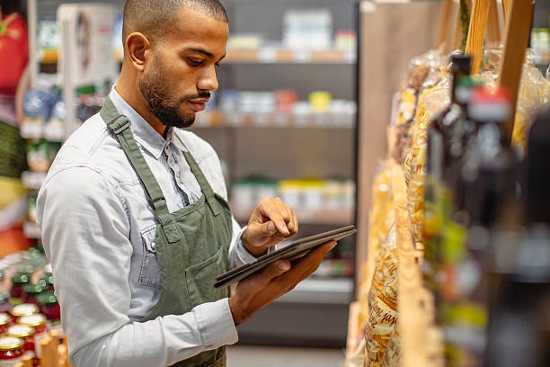 istock Focused Multiracial Male Grocery Worker Using Digital Tablet in Store Aisle 2220128510