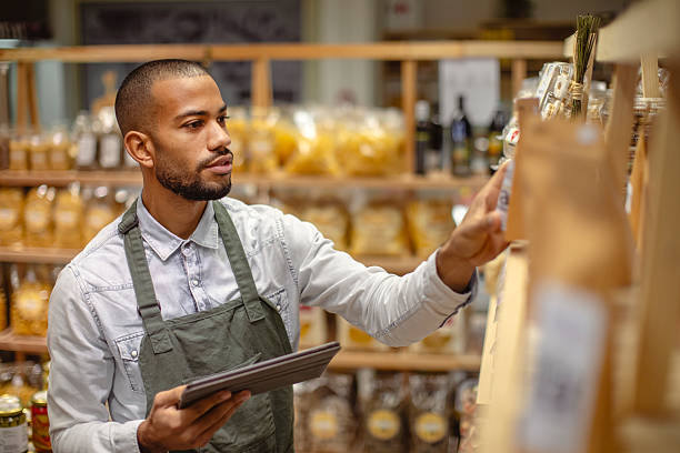 istock Professional Multiracial Store Worker Using Digital Tablet For Inventory Management In Grocery Store 2220128524