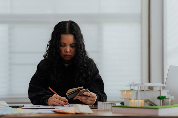 istock A professional female designer working with concentration at her desk planning a creative architecture project 2220130306