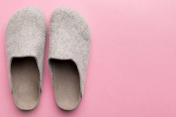 Warm winter women woolen slippers on colored background. Copy space for text.