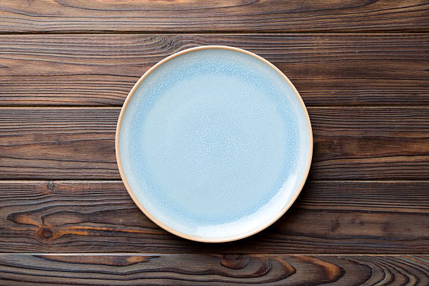 istock Top view of empty blue plate on wooden background. Empty space for your design 2220141012