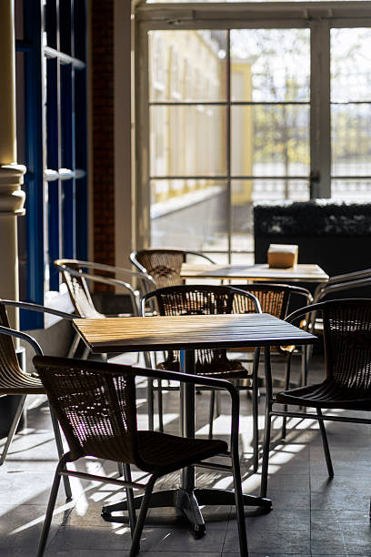 istock Cozy Indoor Cafe Setting With Tables and Chairs Bathed in Warm Sunlight During the Morning Hours 2220142330