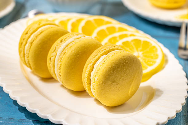 istock Delicious lemon macarons with fresh lemon slices on white plate 2220142441