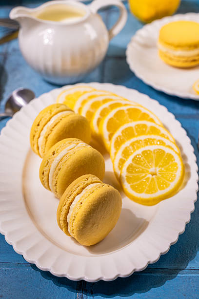 istock Delicious lemon macarons with fresh lemon slices on white plate 2220142451