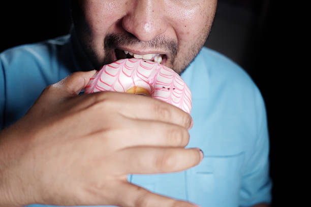 Happy young man enjoying a sweet treat at home