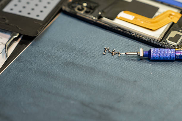istock Expert Phone Repair Technician Working on Device Components in a Repair Shop During the Day 2220144421