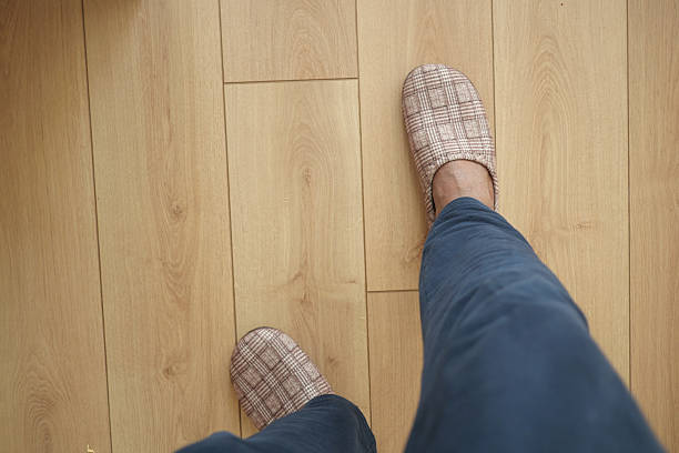 istock Comfortable home slippers on wooden floor during daytime 2220144868