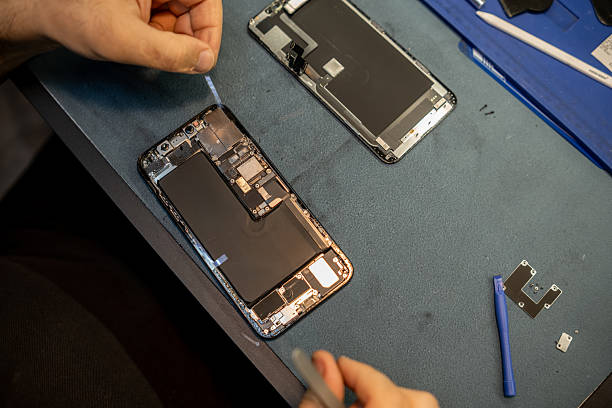 istock Phone Repair Technician Meticulously Works on a Smartphone Disassembly and Replacement in a Repair Shop Setting During the Day 2220145566