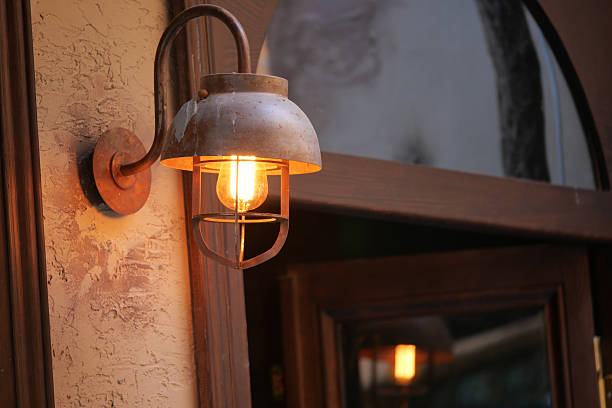 istock Rustic light fixture illuminating an entrance at dusk 2220145882
