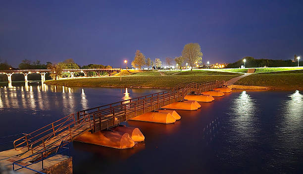 istock Illuminated pontoon footbridge over river at night 2220150255