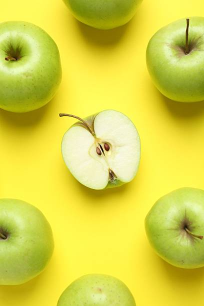 istock Flat lay composition with half of apple surrounded by ones on yellow background 2220151078