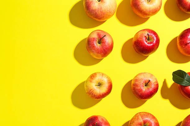 istock Flat lay composition with many red apples on yellow background. Space for text 2220151121