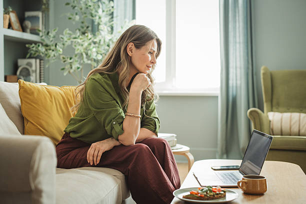 istock Mature woman using laptop at home 2220157892