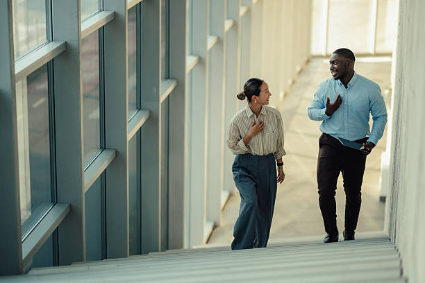 istock Businesspeople walking and talking on stairs in modern office 2220160543
