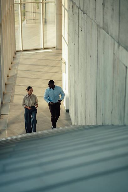 istock Business partners walking and talking in modern office building 2220160544