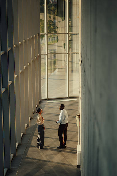 istock Businesspeople discussing strategy in modern office building hallway 2220160550