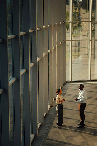 istock Businesspeople discussing strategy in modern office building lobby 2220160551