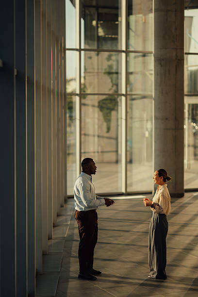 istock Businesspeople discussing work in modern office building lobby 2220160554