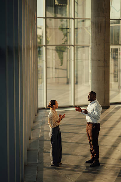 istock Businesspeople discussing work in modern office building lobby 2220160555