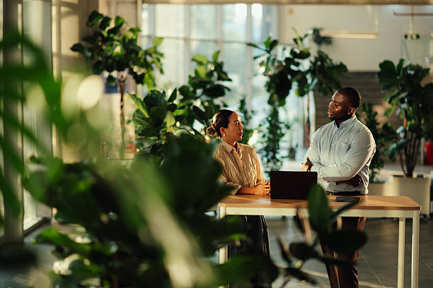 istock Business colleagues discussing a project in a green office space 2220160611