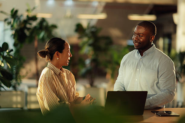 istock Coworkers discussing a project using a laptop in a modern office 2220160627