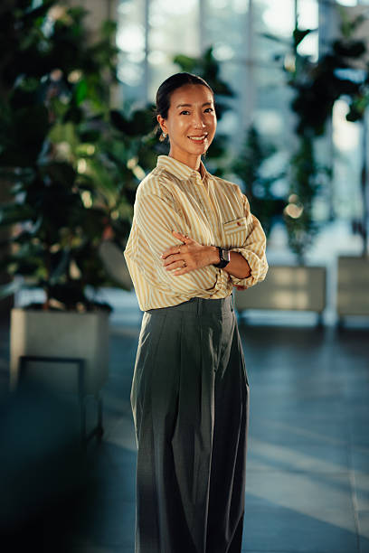 istock Confident businesswoman smiling with folded arms in modern office 2220160639