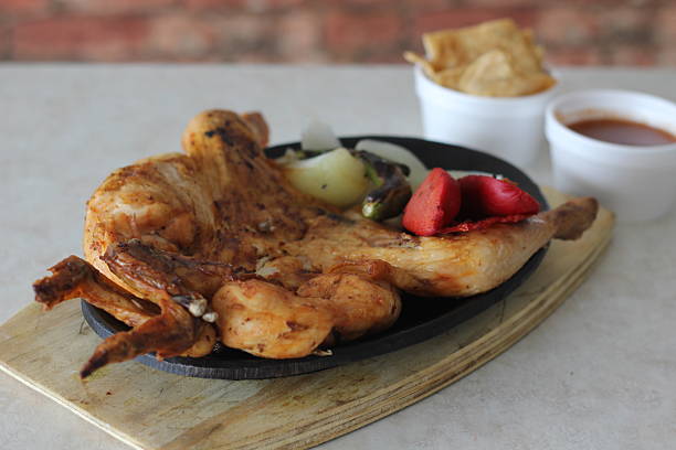 istock A whole grilled chicken served on a sizzling hot plate alongside vegetables 2220160764