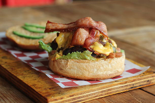 istock A mouth-watering view of a bacon cheeseburger amidst a rustic wooden setting 2220160986