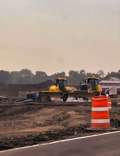 istock Bulldozers at a Road Construction Site with Orange Barrel 2220161721