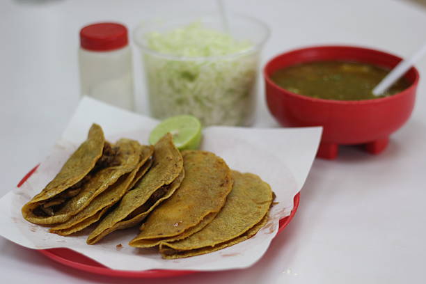 istock A plate featuring crispy tacos accompanied by fresh lettuce and a flavorful broth 2220163000