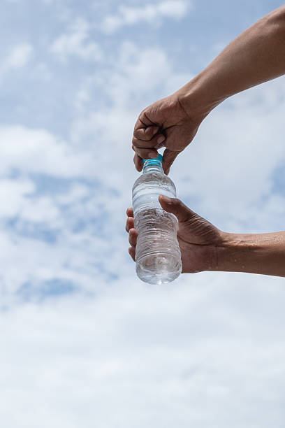 istock Person opening a plastic bottle of water 2220167453