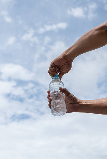 istock Person opening a plastic bottle of water 2220167460
