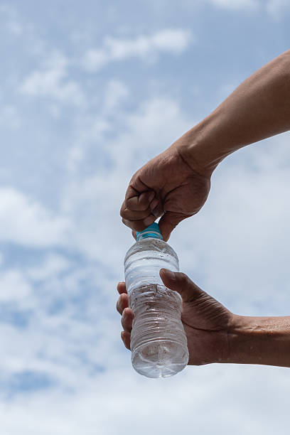 istock Person opening a plastic bottle of water 2220167466
