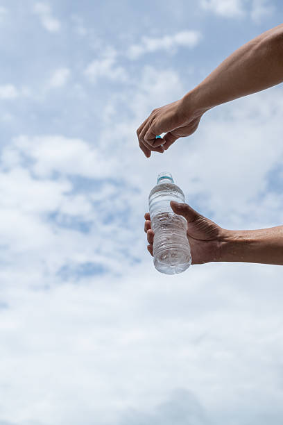 istock Person opening a plastic bottle of water 2220167477