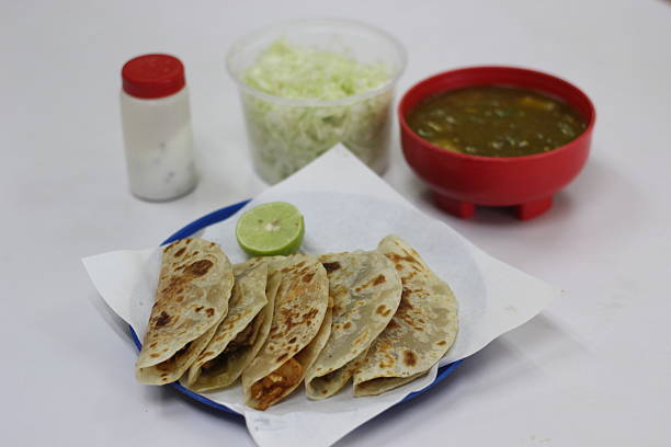 istock A plate filled with freshly made tacos served alongside a rich salsa and crisp lettuce, accompanied by lime for an added zest, representing authentic culinary traditions. 2220171635