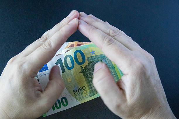 Close up of a person holding a collection of Euro coins.