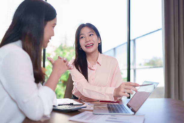 istock Asian Women Discussing Business Strategy with Laptop in Office Setting Collaboration and Data Analysis Brainstorming for Startup Success 2220190364