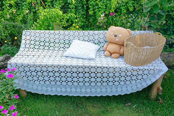 Outdoor Bench with Plastic Lace Cover, Teddy Bear, and Basket in Garden
