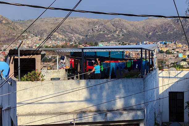 Laundry Day in San Miguel de Allende Guanajuato City, Mexico - May 30th 2016: A woman hangs laundry on a rooftop clothesline, taking advantage of the sunny day to dry her clothes. poverty mexico environment slum stock pictures, royalty-free photos & images